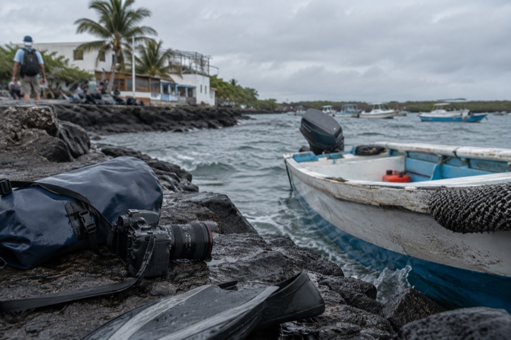 Overcast morning at a panga landing in Puerto Villamil, Galapagos Islands, chop slapping the hull, a scuffed flipper nearby