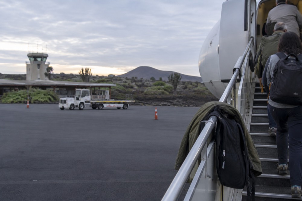 Early cool morning at the Galapagos Islands, Ecuador: mobile airstairs clamp to the open cabin door on the apron at Seymour Airport