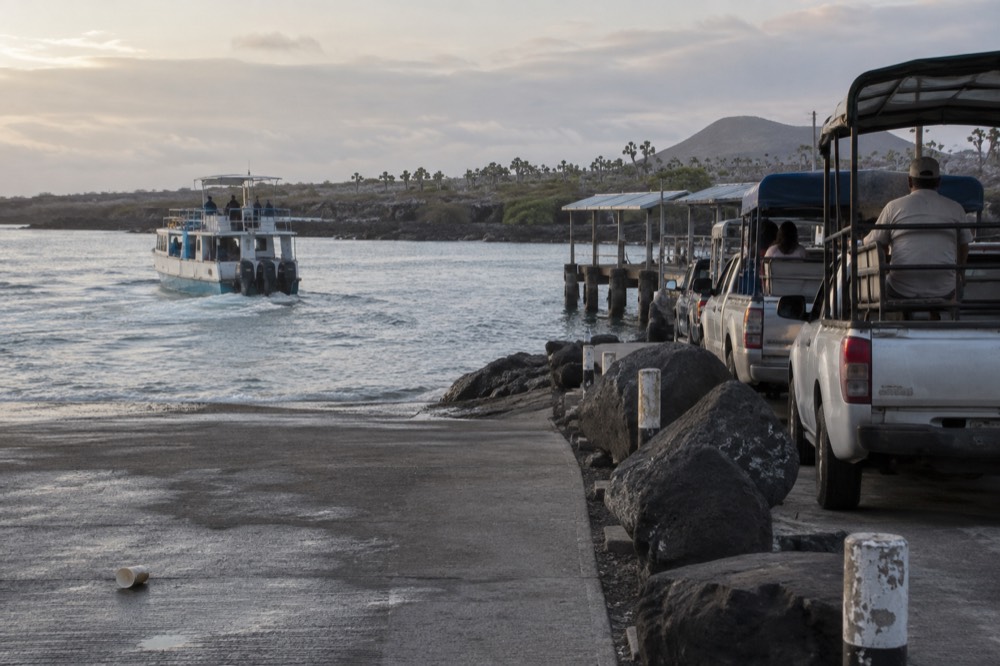 Early morning at the Baltra channel in Ecuador's Galapagos, a small passenger ferry churning grey water toward Santa Cruz
